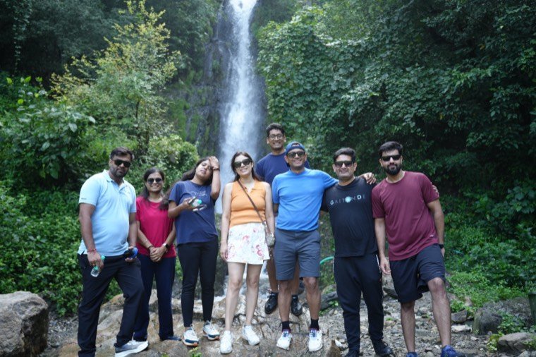 A team on an offsite planned by TrippingCube, at a waterfall